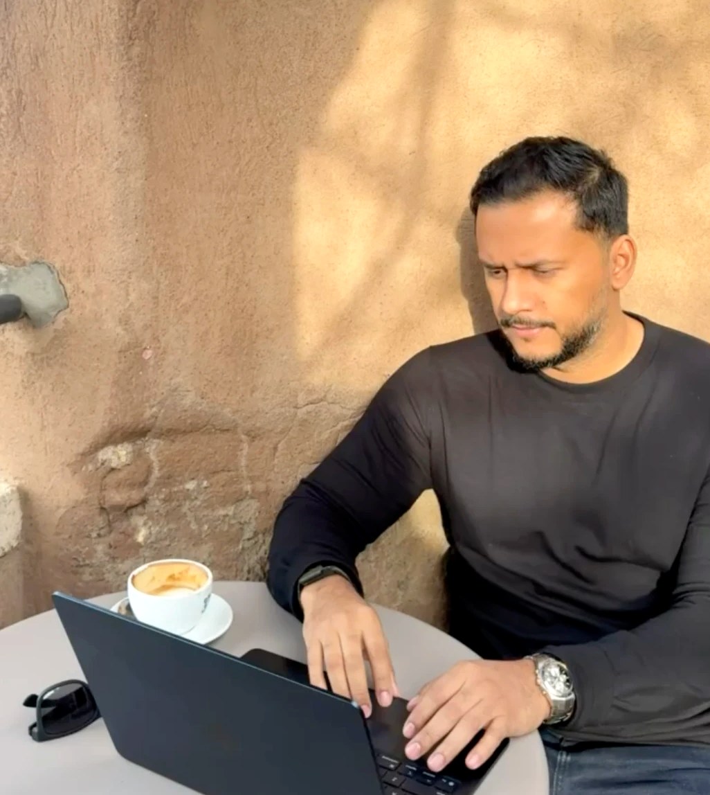 Byron working on a laptop at an outdoor café